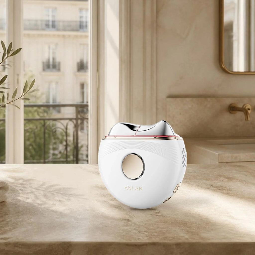 Gua sha électrique chaud et froid ANLAN sur le plan de toilette d’une salle de bain parisienne lumineuse