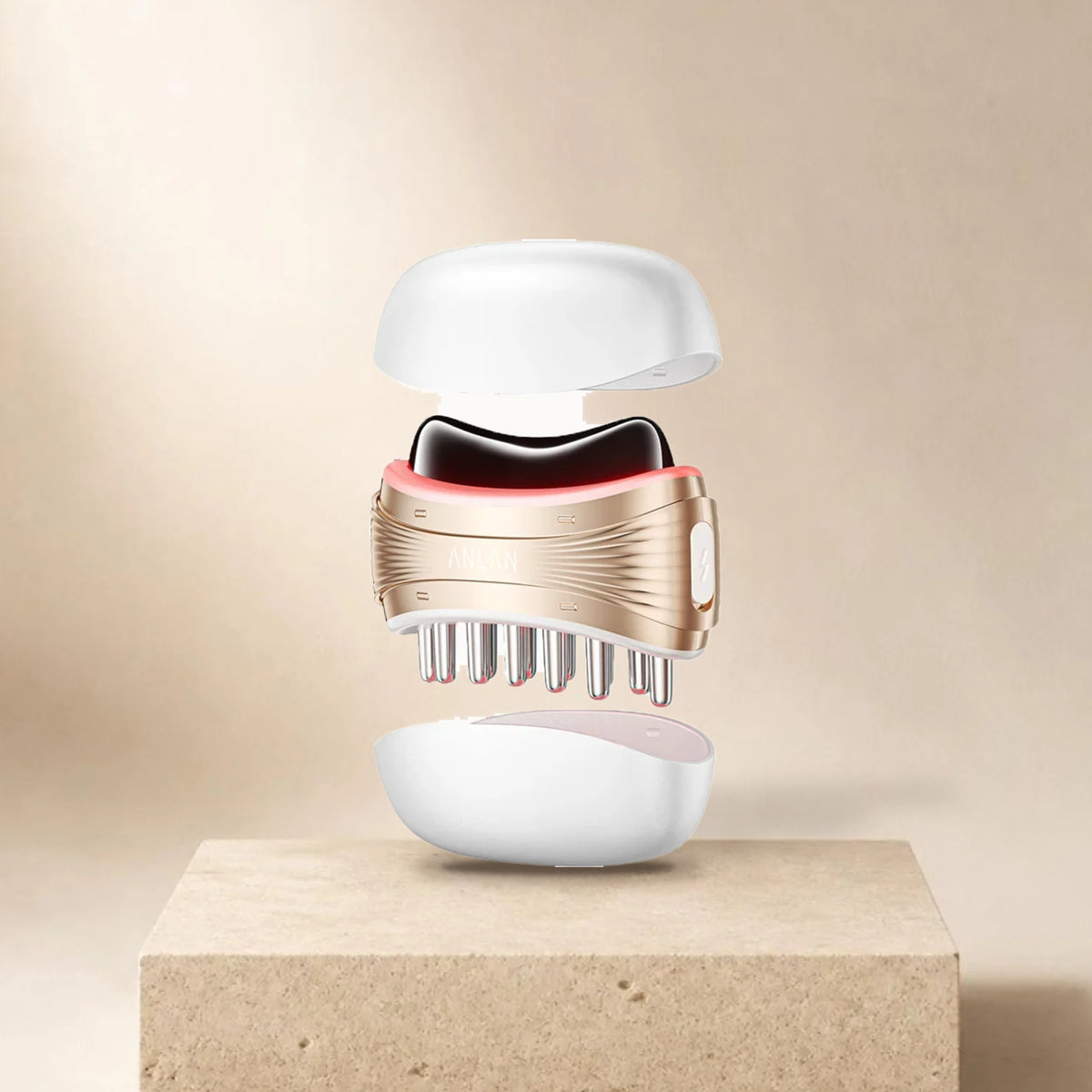 Gua sha électrique 2 en 1 ANLAN (tête en jade, peigne et capots) posé sur un socle en pierre, fond beige