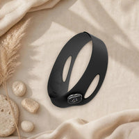 Masque EMS bas du visage ANLAN en silicone noir sur un linge en lin beige
