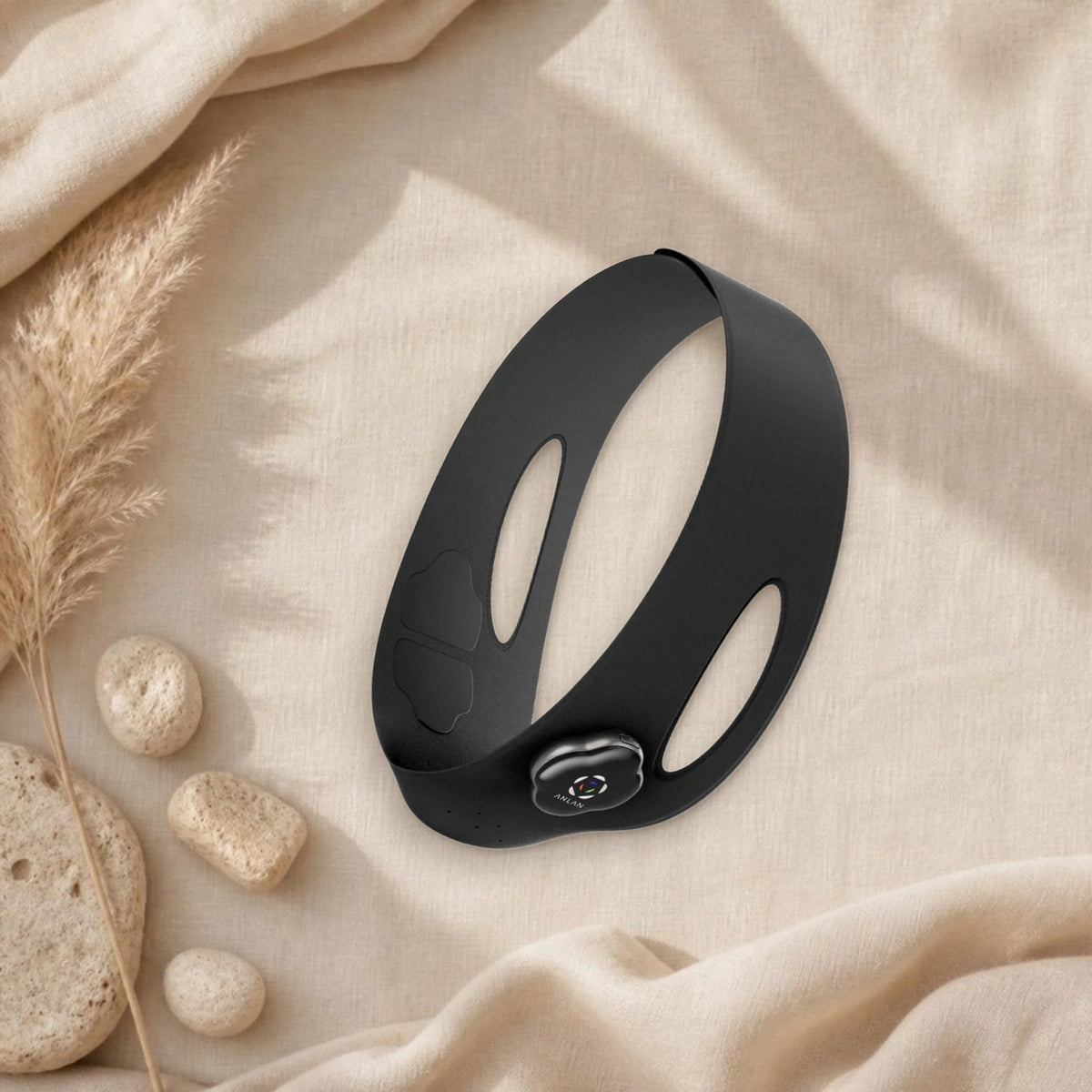 Masque EMS bas du visage ANLAN en silicone noir sur un linge en lin beige