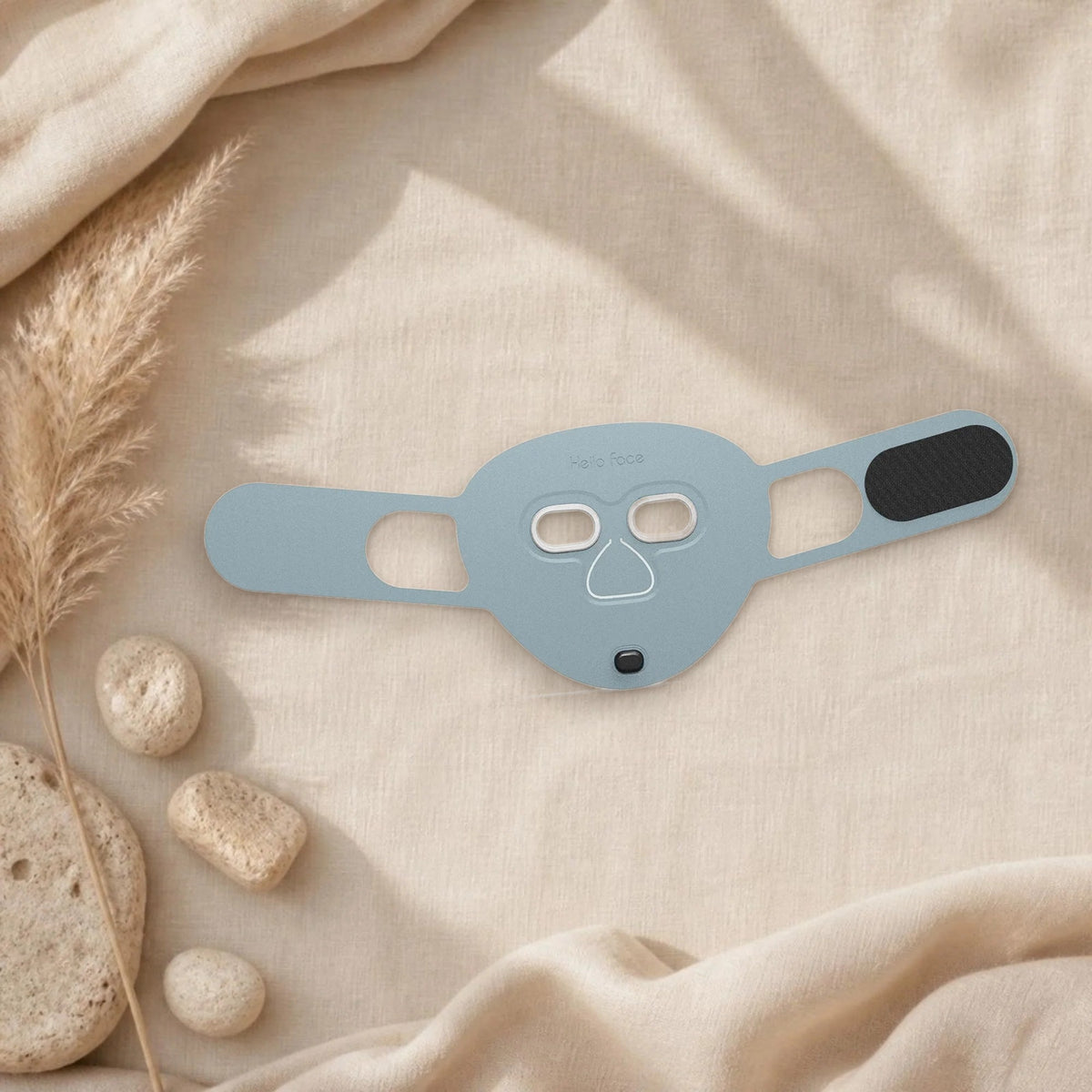 Masque LED visage Hello Face M500S coloris bleu ciel sur un linge en lin beige